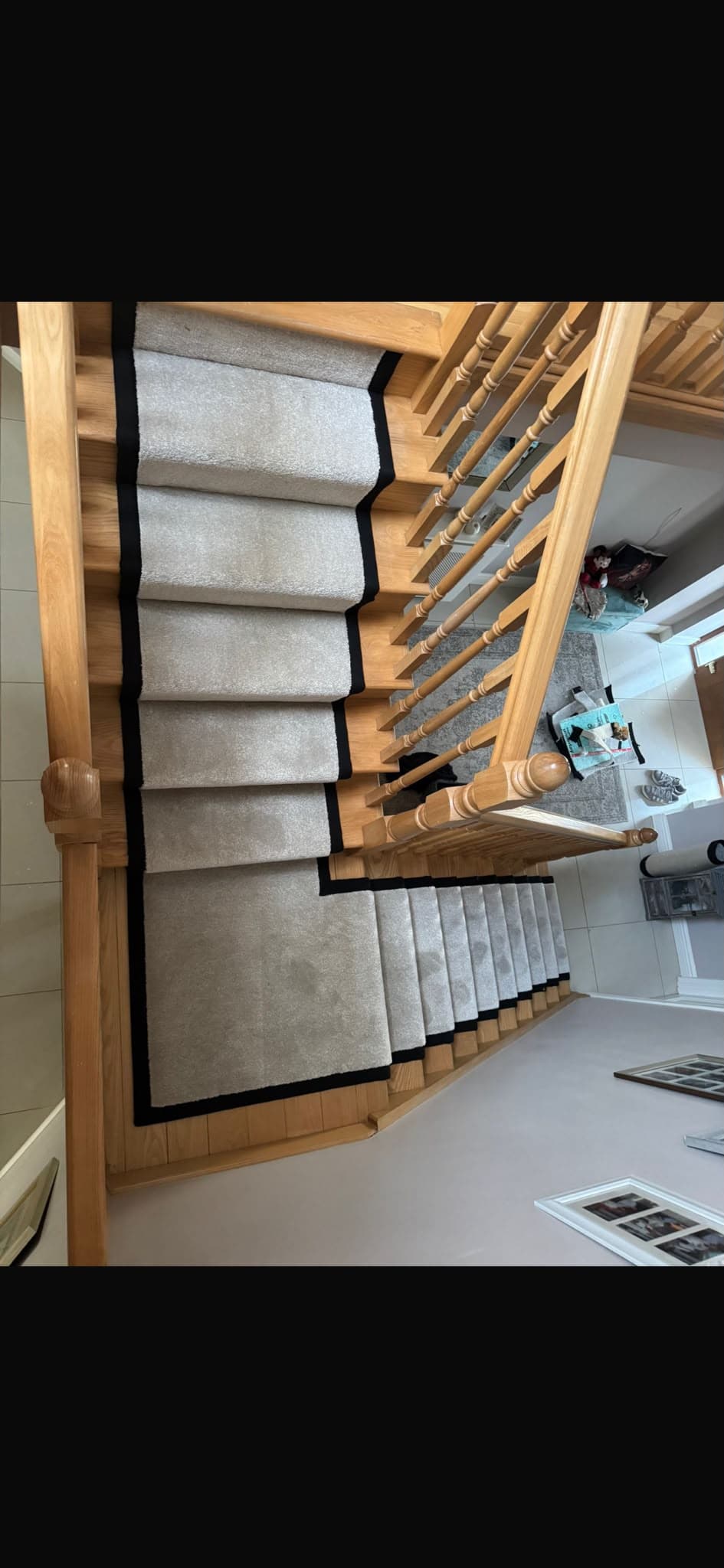 Grey carpet runner with black border trim fitted on a staircase