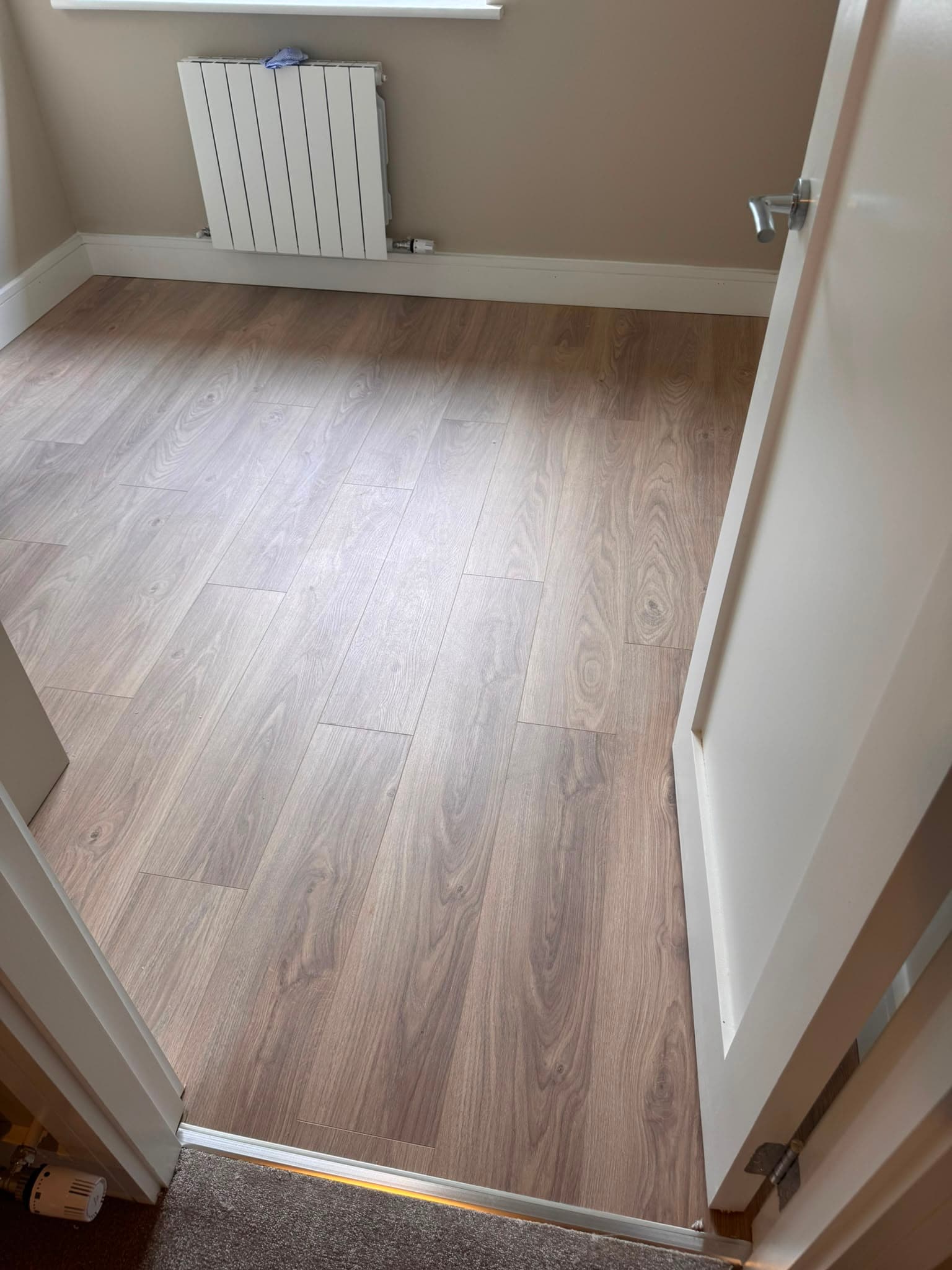 Light oak laminate flooring fitted in a bedroom