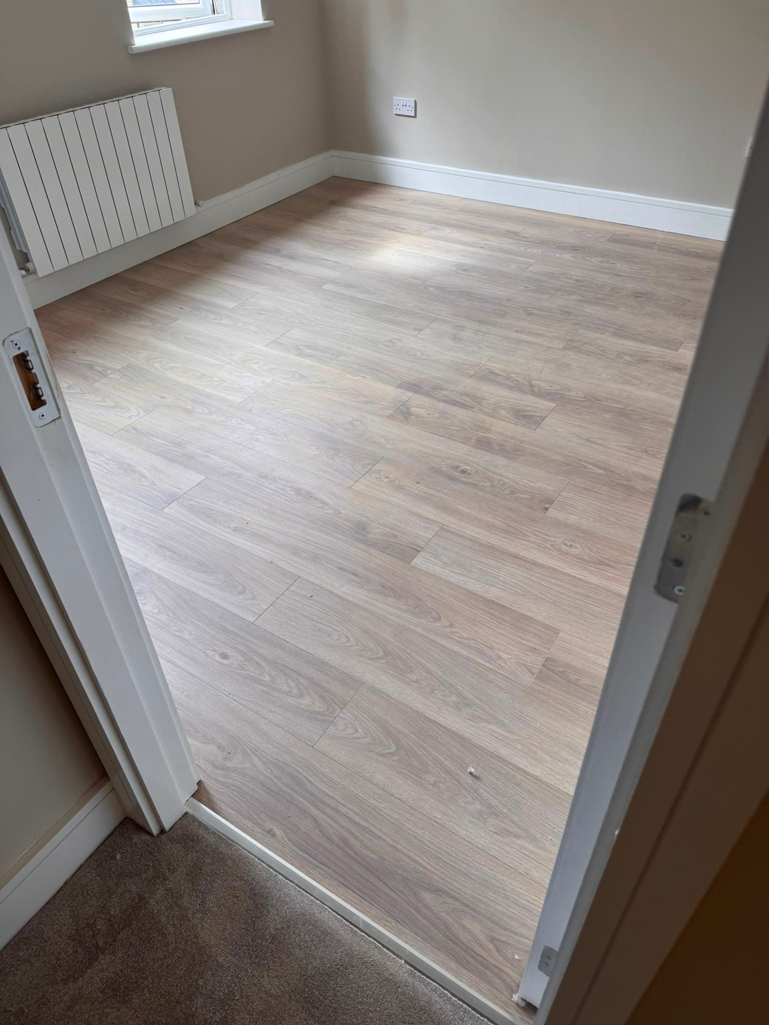 Laminate flooring fitted through two connecting rooms